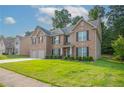 Charming two-story brick home with a well-manicured lawn and attached two-car garage in a suburban neighborhood at 2482 Brittany Park Ln, Ellenwood, GA 30294