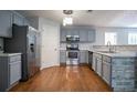 Modern kitchen featuring stainless steel appliances, gray cabinetry, and hardwood floors at 2482 Brittany Park Ln, Ellenwood, GA 30294