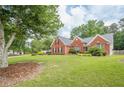 Lovely brick home with green lawn, mature trees, and manicured landscaping at 2870 Jay Oak Dr, Dacula, GA 30019