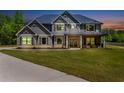 Lovely two-story home with beautiful landscaping and a welcoming front porch, bathed in the evening light at 415 Paynes Lake Rd, Carrollton, GA 30116