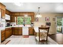 Eat-in kitchen featuring wood cabinets, white appliances, tile floors, and a view to the backyard at 5343 Crystal Ln, Atlanta, GA 30349