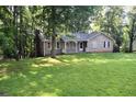 Cozy single-story home featuring a welcoming front porch and surrounded by a lush green lawn and mature trees at 157 Sequoyah Cir, Canton, GA 30115