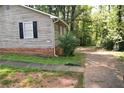 View of a home's exterior showcasing the siding, window with black shutters, and partial driveway at 157 Sequoyah Cir, Canton, GA 30115