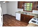 Traditional kitchen with brown cabinets, a white dishwasher, and a double stainless steel sink with wood look floors at 157 Sequoyah Cir, Canton, GA 30115