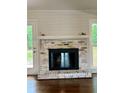 Close up of the fireplace featuring a brick surround, a white mantle, and shiplap accents at 1743 Moss Dr, Snellville, GA 30078
