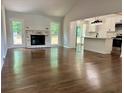 Inviting living room featuring hardwood floors, a fireplace with brick surround, and natural light at 1743 Moss Dr, Snellville, GA 30078