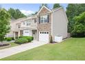 Attractive townhome exterior showcasing a stone facade, one-car garage, and lush green lawn at 257 Ridge Mill Dr, Acworth, GA 30102