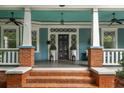 Inviting front porch with brick accents, white columns, and a stylish black front door at 1038 Saint Charles Ave, Atlanta, GA 30306