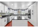 This kitchen features white cabinets, a dark countertop, an island, and modern appliances at 1647 Grandeus Sw Ln, Stone Mountain, GA 30087
