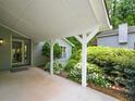 Covered entrance with white supports framed by garden area with a lush landscape at 4766 Jamerson Forest Cir, Marietta, GA 30066