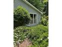 A close up view of the home showcasing the manicured garden and large window for natural light at 4766 Jamerson Forest Cir, Marietta, GA 30066
