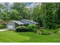 Ranch style home with mature trees and a well-manicured lawn in a wooded setting at 4766 Jamerson Forest Cir, Marietta, GA 30066