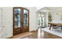Inviting entryway with glass paneled double doors, opening to a dining area with natural light at 505 Woodmoore Ct, Sandy Springs, GA 30342