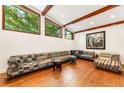 Spacious living room with hardwood floors, exposed beams, and oversized windows showcasing the backyard at 1164 Bonview Ne Ln, Atlanta, GA 30324