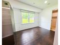 Bright dining room with dark hardwood floors, wainscoting, and a large window offering natural light at 241 Sarann Nw Ct, Lilburn, GA 30047