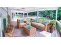 Inviting porch with wicker furniture, including a sofa, chairs, and a coffee table, for outdoor relaxation at 241 Sarann Nw Ct, Lilburn, GA 30047