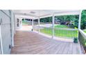 Spacious covered porch featuring wood-look tile flooring, white columns, and black metal railings at 241 Sarann Nw Ct, Lilburn, GA 30047