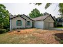 View of the home's exterior, highlighting the two-car garage, front door, and yard at 515 Allens Landing Ct, Lawrenceville, GA 30045