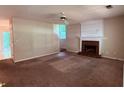 Open living room featuring a fireplace and a ceiling fan at 7250 Bridgeport Ct, Austell, GA 30168