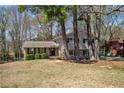 Exterior view of a brick and siding home surrounded by mature trees and landscaping at 3937 Locklear Way, Atlanta, GA 30360