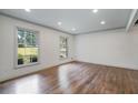 Bright living room showcasing dark hardwood floors, white walls, recessed lighting, and large windows at 3937 Locklear Way, Atlanta, GA 30360