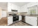 Well-equipped kitchen featuring stainless steel appliances, granite countertops, and white cabinets at 586 Chris Cir, Lawrenceville, GA 30044