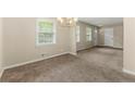 Cozy living room featuring neutral paint, plush carpet, and a classic chandelier lighting fixture at 586 Chris Cir, Lawrenceville, GA 30044