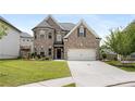Attractive two-story home with a brick facade, a well-maintained lawn, and a double garage at 829 Overlook Path Ln, Lawrenceville, GA 30045