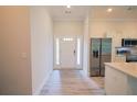 Open entryway with white door, luxury vinyl plank flooring, stainless steel appliances at 275 Green Commons Dr, Covington, GA 30016
