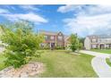 Brick home with an expansive green lawn and landscaped garden beds with maturing trees at 403 Sonja Ln, Loganville, GA 30052