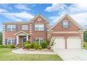 Beautiful brick home featuring a two-car garage, well-kept lawn, and charming blue shutters at 403 Sonja Ln, Loganville, GA 30052