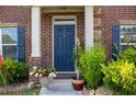 Inviting brick home featuring a stately blue front door and well-manicured landscaping at 403 Sonja Ln, Loganville, GA 30052