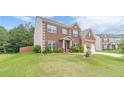 A well-maintained lawn surrounds this brick home with blue shutters on a bright day at 403 Sonja Ln, Loganville, GA 30052