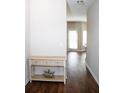Bright hallway featuring hardwood floors and a charming console table with floral basket at 403 Sonja Ln, Loganville, GA 30052