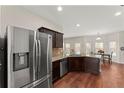 Open kitchen boasts stainless steel appliances, granite counters, and hardwood floors, flowing into the breakfast area at 403 Sonja Ln, Loganville, GA 30052