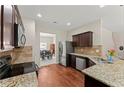 Well-lit kitchen featuring granite countertops, stainless steel appliances, and hardwood floors with eat in kitchen at 403 Sonja Ln, Loganville, GA 30052