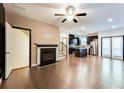 Open-concept living room with fireplace, dark trim, hardwood floors, and view of the kitchen at 992 Belfry Ter, Fairburn, GA 30213