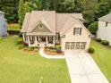 Aerial view of home with mature trees, a well-kept lawn, and a paved driveway at 2059 Ivey Chase Dr, Dacula, GA 30019