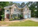 Traditional brick home featuring an attached two car garage and professional landscaping at 921 Laurel Crest Dr, Woodstock, GA 30189