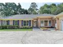 Charming brick home featuring a symmetrical facade, lush greenery, and a spacious driveway at 1758 N Springs Dr, Atlanta, GA 30338