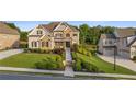 Beautiful two-story home with lush green lawn, manicured landscaping, and a welcoming entrance at 2377 Kesgrove Way, Buford, GA 30518
