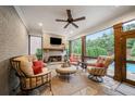 Cozy screened porch with fireplace, comfortable seating, and views of the pool and lush greenery at 2377 Kesgrove Way, Buford, GA 30518