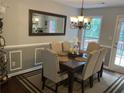 Formal dining room featuring wainscoting, a decorative mirror, and seating for six at 340 Fountainmist Trl, Lawrenceville, GA 30043