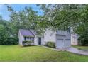 Traditional home featuring a well manicured lawn, clean white siding, and a two car garage at 5421 Salem Springs Dr, Lithonia, GA 30038
