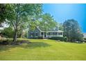 Beautiful two-story house featuring a lush green lawn and mature trees on a sunny day at 1851 Harvest Way, Loganville, GA 30052