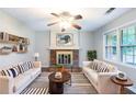 Inviting living room with a brick fireplace, ceiling fan, and large window offering natural light at 604 Hamlet Se Ct, Conyers, GA 30094