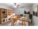 Bright office space with a large desk, bookshelves, ceiling fan and natural lighting at 604 Hamlet Se Ct, Conyers, GA 30094