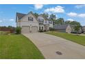 Inviting two-story home with a spacious driveway and a two-car garage, set against a lush green lawn at 6135 Stillwood Ln, Cumming, GA 30041