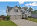 Lovely two-story home with a two-car garage and a spacious driveway, surrounded by green landscaping at 6135 Stillwood Ln, Cumming, GA 30041
