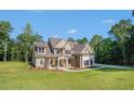 Beautiful two-story home with covered porch and lush greenery in a serene, wooded setting at 177 West Lake Blvd, Carrollton, GA 30116